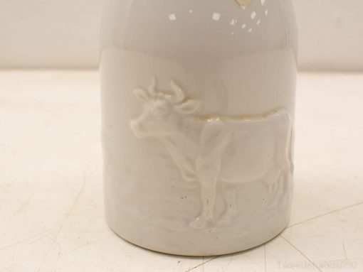 Elegant white ceramic bottle with embossed cow, perfect for vintage and rustic home decor.