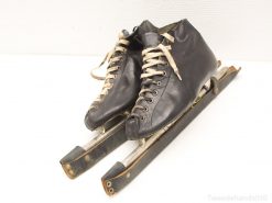 Classic black leather ice skates with cream laces and polished steel blades, showcasing timeless craftsmanship.