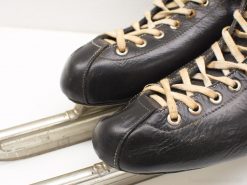 Vintage black leather size 44 ice skates with polished blades, blending style and functionality.