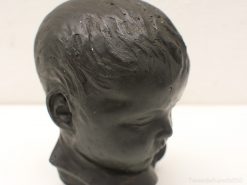 Realistic black ceramic sculpture of a childs head, embodying innocence and nostalgia.