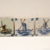 Ceramic tiles featuring traditional Dutch windmills in serene blue and earthy tones.