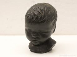 Serene child bust sculpture in dark material, showcasing innocence and thoughtful tranquility.