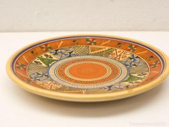 Handcrafted Peruvian ceramic plate featuring vibrant geometric patterns and intricate designs.