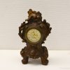 Vintage Baroque bronze tabletop clock with intricate details and Roman numerals, adding classic charm.