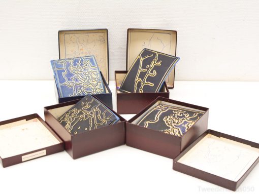 Elegant decorative plates with intricate blue and gold designs in luxurious wooden boxes.