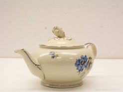 Elegant cream porcelain teapot with blue floral design, perfect for serving tea and decorative display.