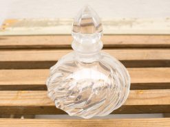 Elegant vintage glass perfume bottle with teardrop stopper, adding charm to any decor.