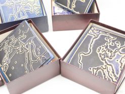 Elegant burgundy boxes showcasing unique geometric ceramic designs, ideal for collectors and art enthusiasts.