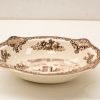 Elegant vintage dish featuring intricate floral designs and a castle scene, ideal for décor.