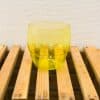 Bright yellow glass bowl on rustic wood, adding cheerful elegance to any space.