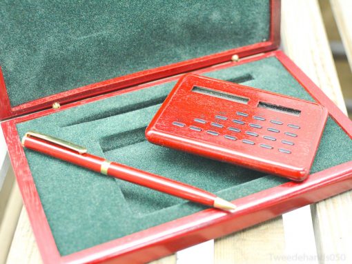 Sophisticated pen and calculator gift set in a polished wooden box with green velvet interior.