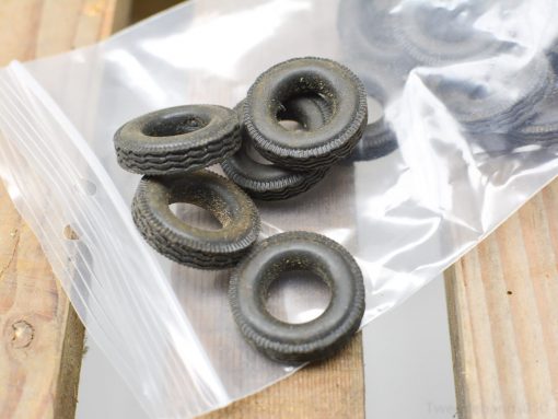 Miniature rubber tires in a bag, ideal for model cars and creative projects.