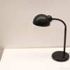 Elegant black desk lamp with a curved arm and dome shade for modern decor.