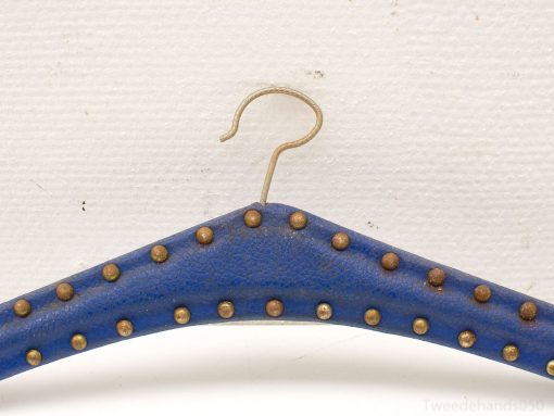 Vibrant blue hanger with brass studs, combining style and functionality for a chic wardrobe addition.