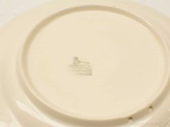 Vintage cream porcelain plate with a glossy finish and faint makers mark, ideal for collectors.