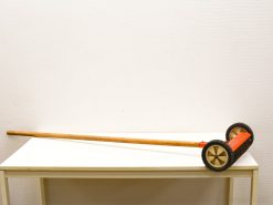 Playful vintage wooden garden tool with colorful wheels, perfect for decor and creativity.