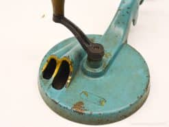 Vintage teal mechanical tool with wooden handle, showcasing unique character and nostalgic charm.