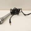 Vintage silver microphone with coiled cable, ideal for performances and professional audio use.