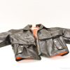 Stylish black leather kids jacket with vibrant orange lining and silver hardware accents.