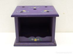 Charming purple wooden storage box with floral motifs and circular openings for organization.