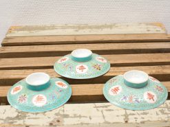 Antique Chinese turquoise porcelain plates with vibrant floral designs and red symbols.