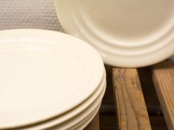 Elegant vintage cream dinner plates stacked on rustic wood, perfect for any dining occasion.