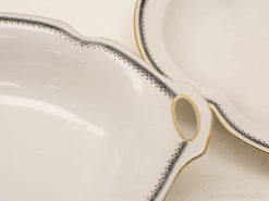 Elegant porcelain serving set with gold accents, including an oval platter and round dish.