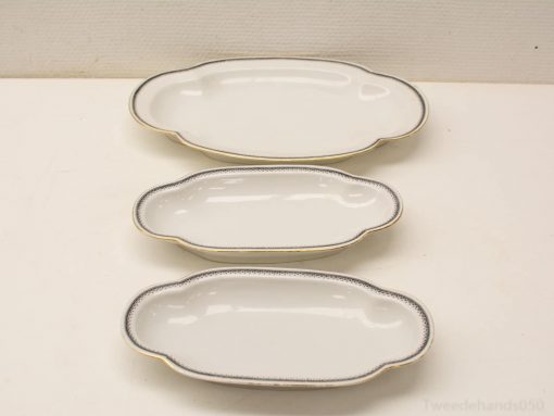 Elegant porcelain serving dishes set for formal occasions, featuring graceful designs and gold accents.