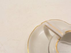 Elegant porcelain teacup with a golden rim and a charming history. Perfect for tea lovers.