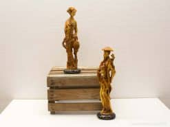 Intricate wooden sculptures of a man and woman highlighting cultural artistry and craftsmanship.