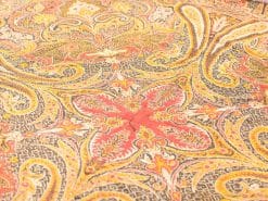 Vibrant vintage tablecloth with intricate floral and paisley patterns in rich colors.