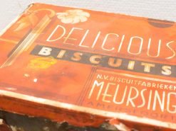 Vintage Meursing biscuit box with bold DELICIOUS text, warm orange color, and nostalgic charm.