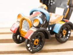 Charming vintage ceramic car model in glossy black with vibrant red, yellow, and blue accents.