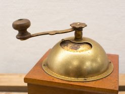 Vintage brass coffee grinder with wooden base, perfect for coffee lovers and antique collectors.