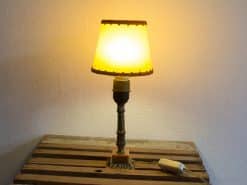 Charming vintage lamp with yellow shade and bronze base, perfect for creating a cozy atmosphere.