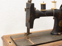 Vintage Pfaff sewing machine with ornate floral design and colorful threads, perfect for collectors.