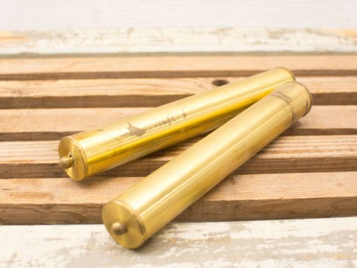 Vintage brass tubes on rustic wood, showcasing elegance and character. Perfect for collectors.