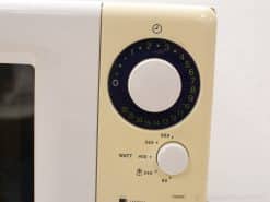 Vintage microwave oven control panel with timer dial and adjustable wattage settings, retro charm.