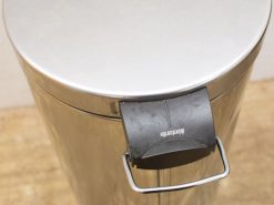 Sleek 30L stainless steel trash bin with integrated handle for modern interiors.