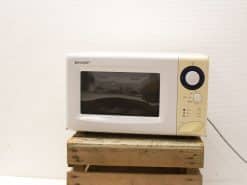 Sleek Sharp microwave with elegant gold trim, perfect for small kitchens and quick meals.