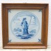 Charming ceramic plate depicting a shepherd with animals, framed in rustic wood.