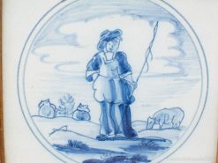 Charming vintage Delftware painting of a shepherd in a serene pastoral scene.