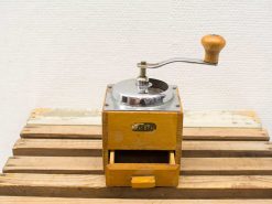 Vintage wooden coffee grinder with metal mechanism, showcasing timeless charm and practicality.