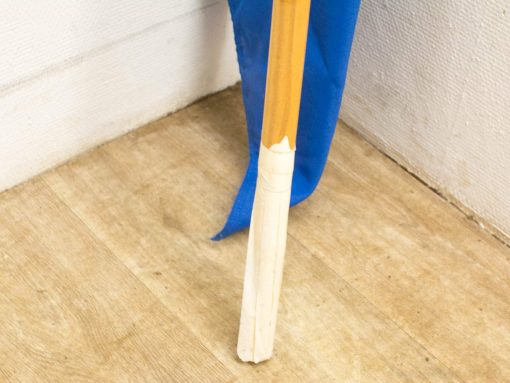 Stylish wooden broom handle with vibrant blue fabric for vintage decor and unique displays.