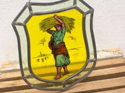 Stained glass artwork celebrating agricultural life with a dedicated farmer and vibrant colors.