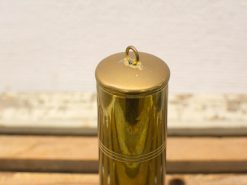 Stylish brass container with grooves and hanging loop, perfect for keys or decor.