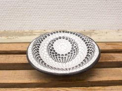 Elegant black and white ceramic plate with intricate patterns, perfect for decor or serving.