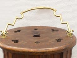 Rustic wooden container with zigzag brass handle and artistic cut-outs for storage or decoration.