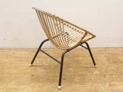 Stylish modern rattan chair with curved backrest and sturdy metal frame. Perfect for contemporary decor.