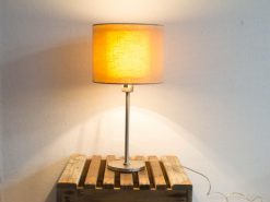 Elegant vintage lamp on rustic wooden crate, blending modern design with warm ambiance.